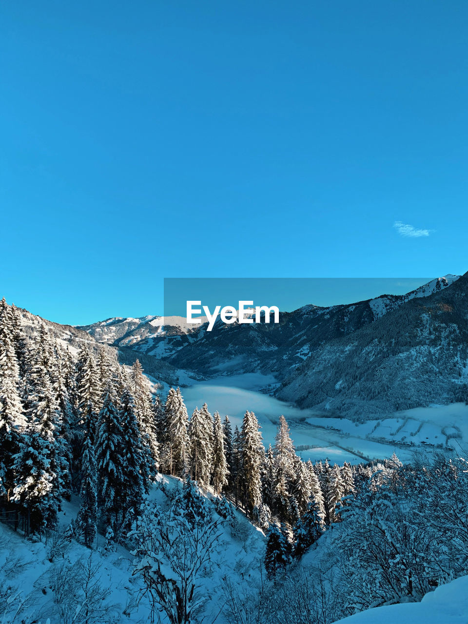 Scenic view of snowcapped mountains against clear blue sky