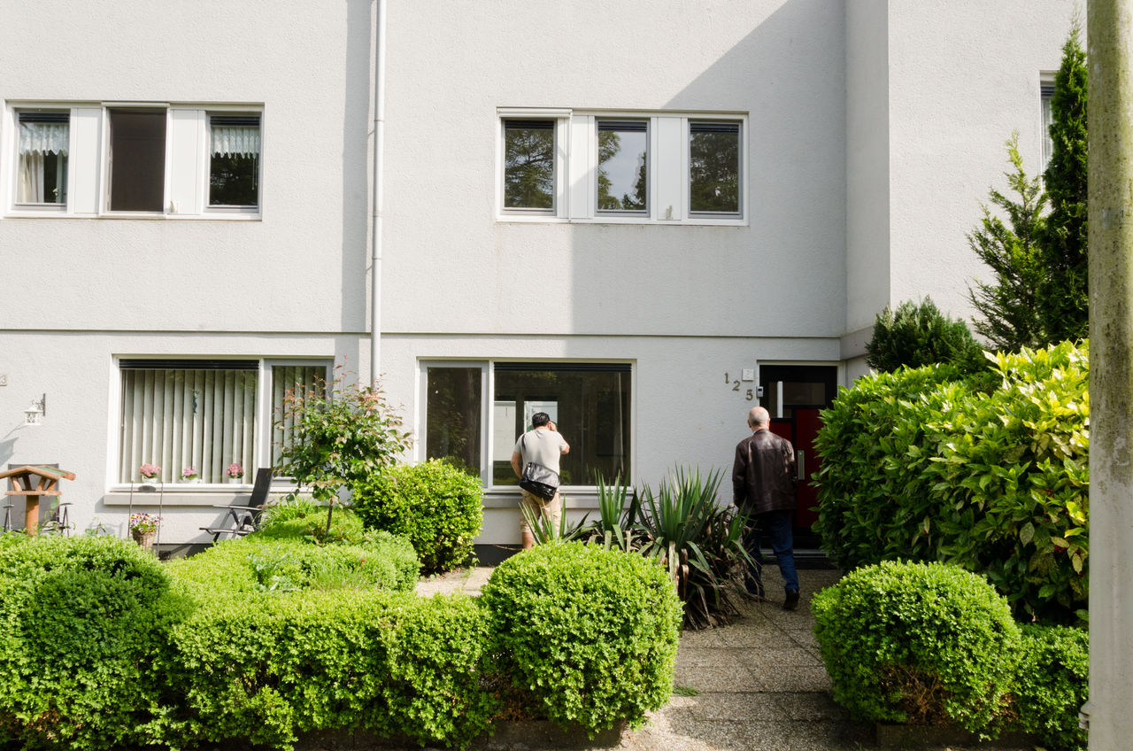 REAR VIEW OF PEOPLE WALKING IN BUILDING