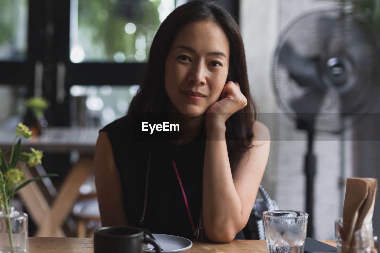 Portrait of asian woman sitting at restaurant table