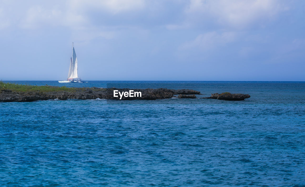 sea, water, sailboat, sky, nautical vessel, sailing, horizon over water, cloud, beauty in nature, ocean, horizon, transportation, scenics - nature, nature, vehicle, sailing ship, travel, mode of transportation, blue, tranquil scene, yacht, ship, tranquility, idyllic, coast, land, boat, shore, holiday, no people, day, vacation, environment, outdoors, trip, yachting, travel destinations, bay, beach, tower, non-urban scene, motion, luxury, watercraft, seascape, mast, cruise, tourism