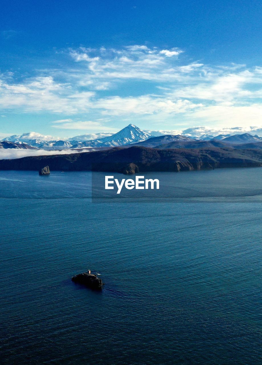 Scenic view of sea and mountains against sky