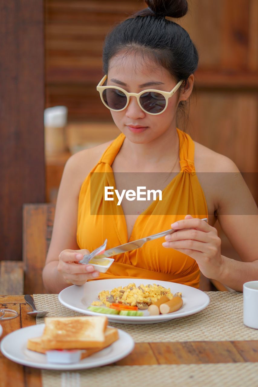 Beautiful young woman having food in restaurant