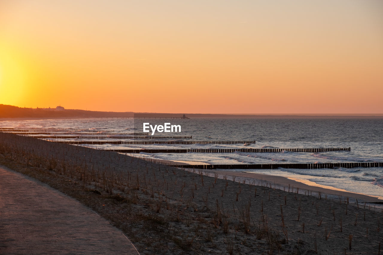 SCENIC VIEW OF BEACH AGAINST SKY DURING SUNSET