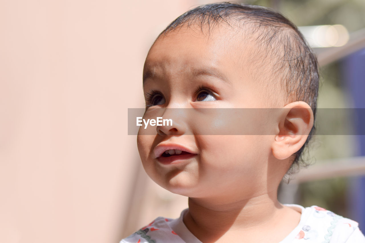 Close-up of cute baby girl looking away