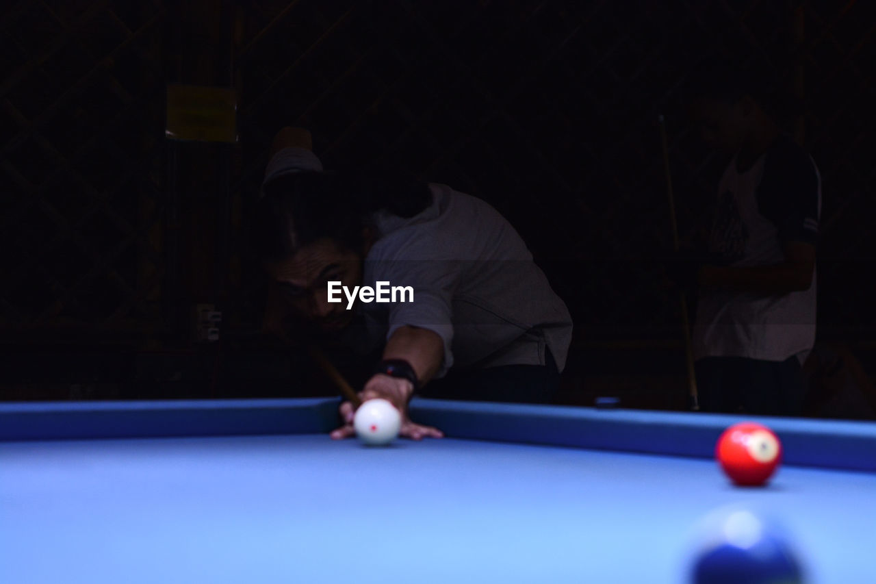 pool ball, pool sport, pool table, sports, ball, billiards, pool cue, table, leisure activity, aiming, concentration, indoor games and sports, billiard table, leisure games, cue stick, indoors, relaxation, snooker, bending, pool hall, adult, billiard room, young adult, recreation, men, bar, nine-ball, game, skill, one person, eight-ball, individual sports, sports equipment, billiard ball, lifestyles, competition, cue ball, night, accuracy, leaning, arts culture and entertainment, recreation room, sphere, casual clothing, nightlife