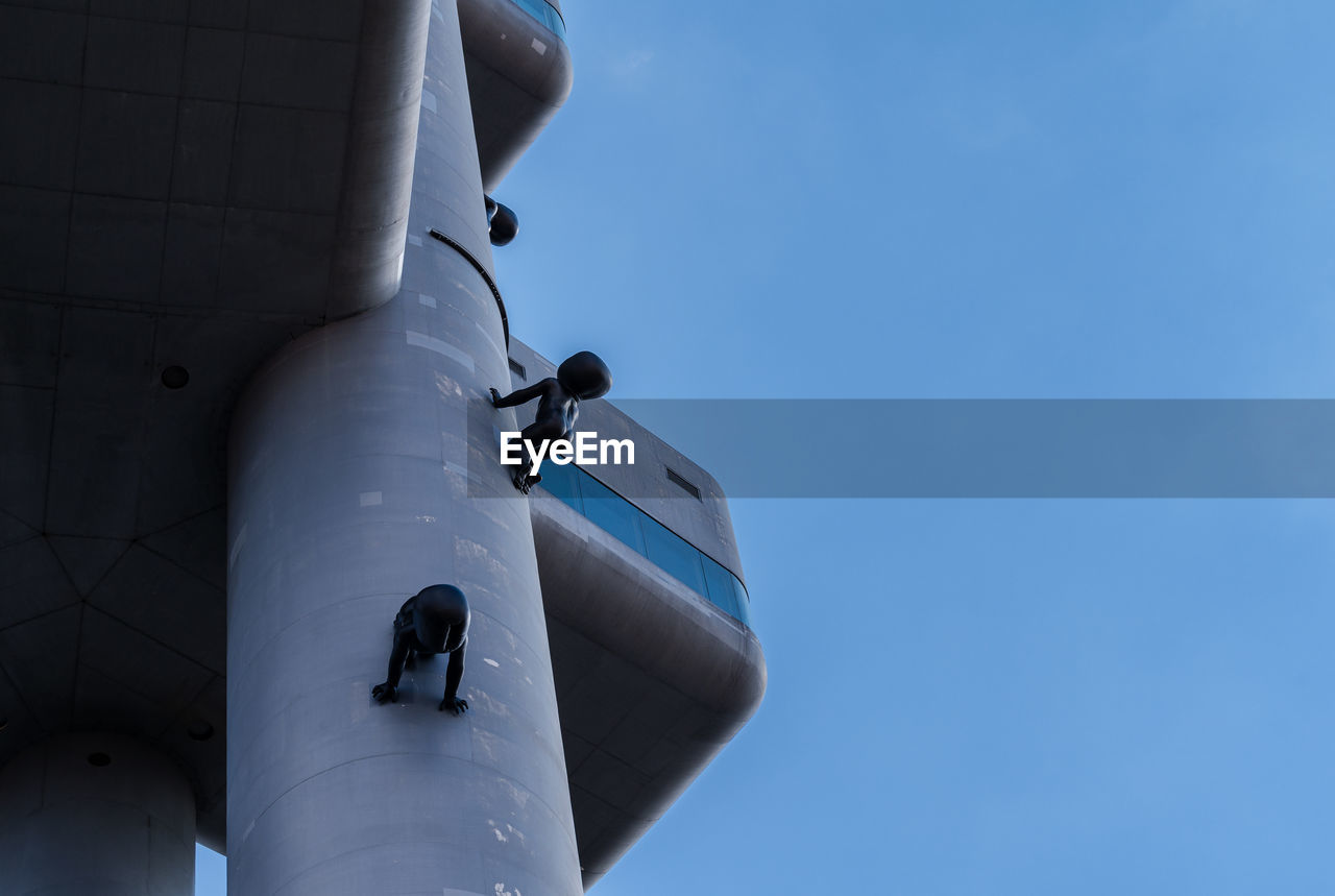 LOW ANGLE VIEW OF AIRPLANE FLYING AGAINST BLUE SKY