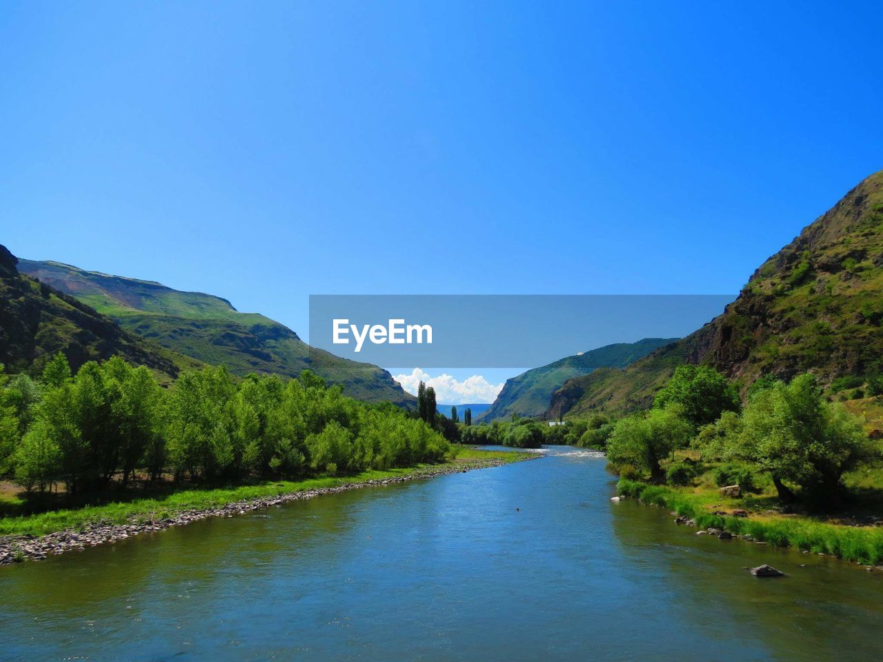 Scenic view of lake against clear blue sky