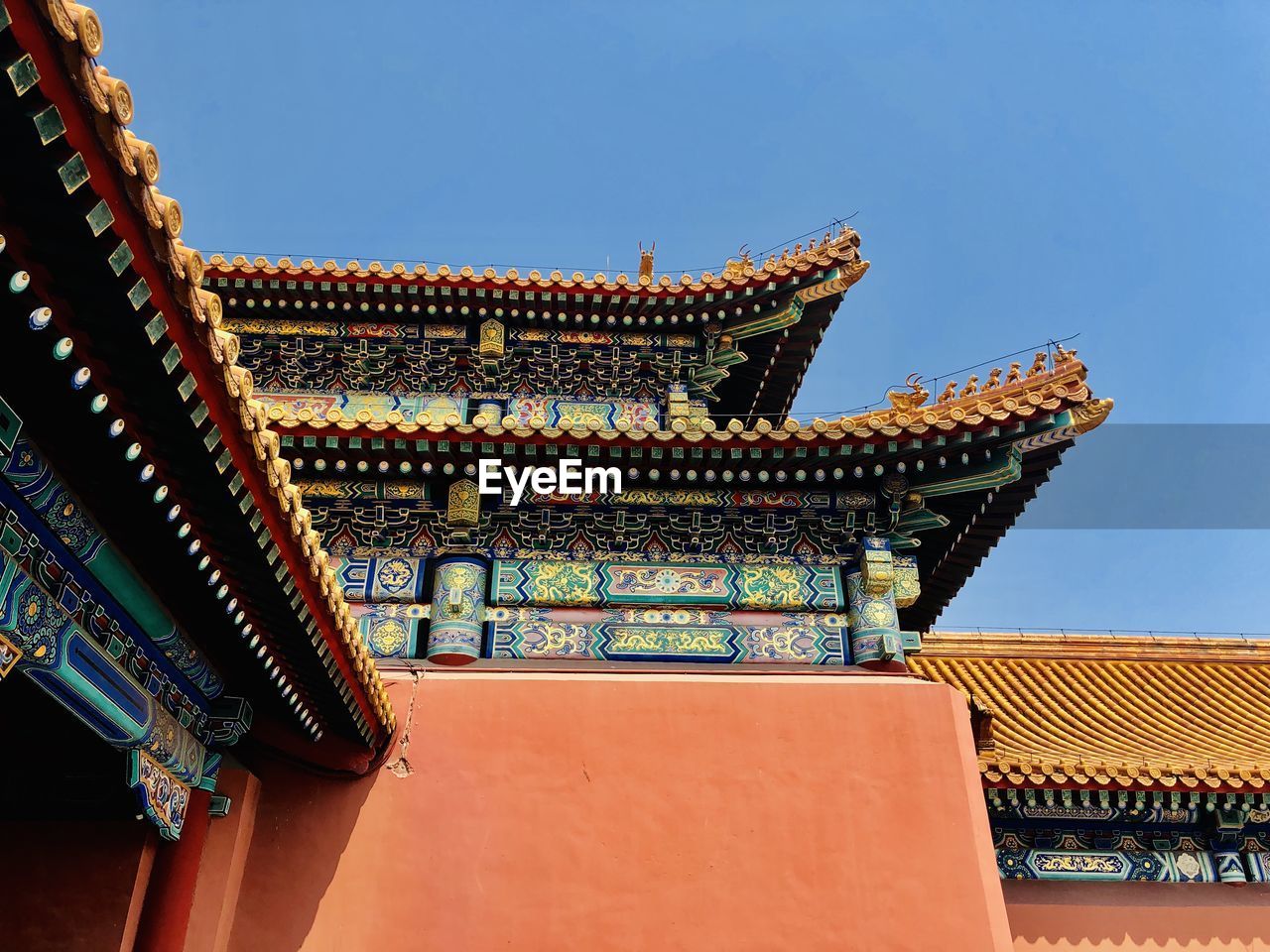 LOW ANGLE VIEW OF TEMPLE ROOF AGAINST BUILDING