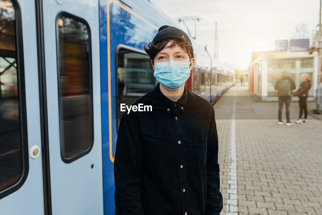 Portrait of man standing on train at railroad station