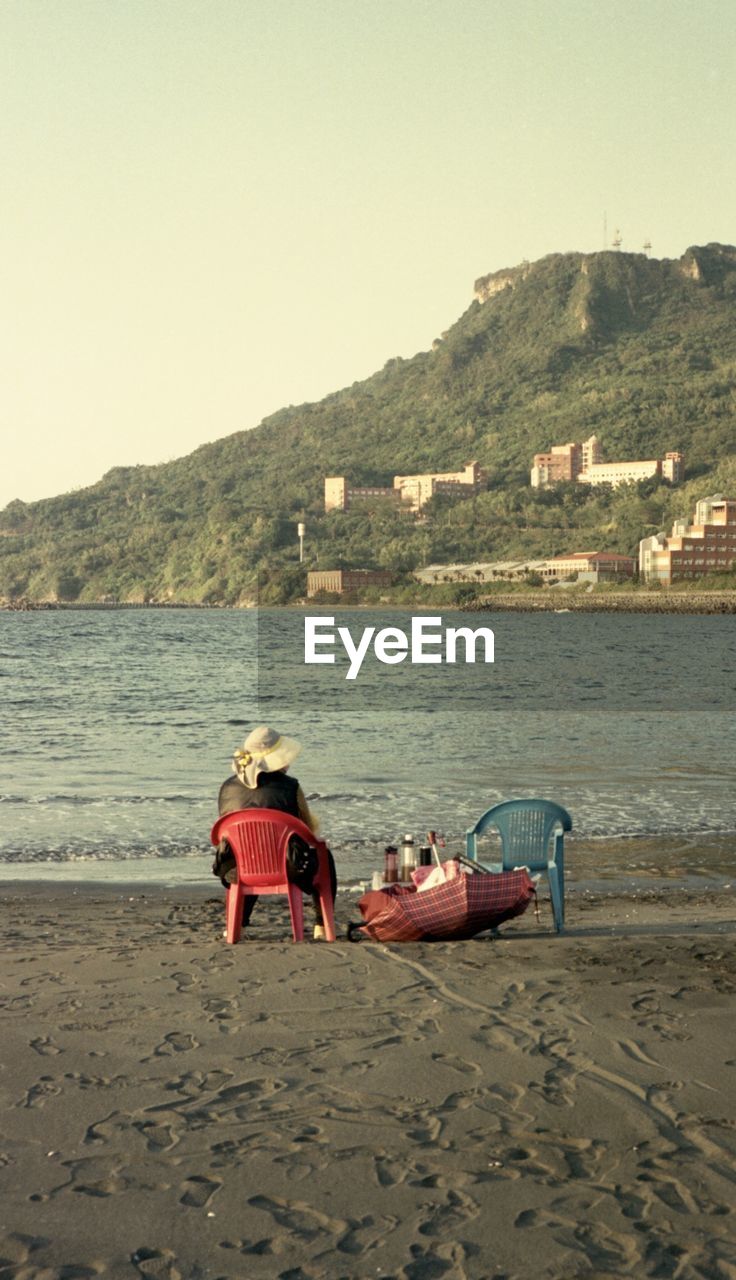 rear view of woman sitting on beach