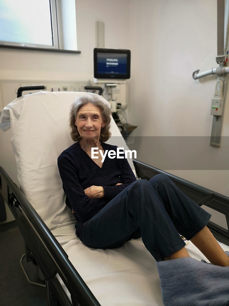 Portrait of senior woman relaxing on bed at hospital