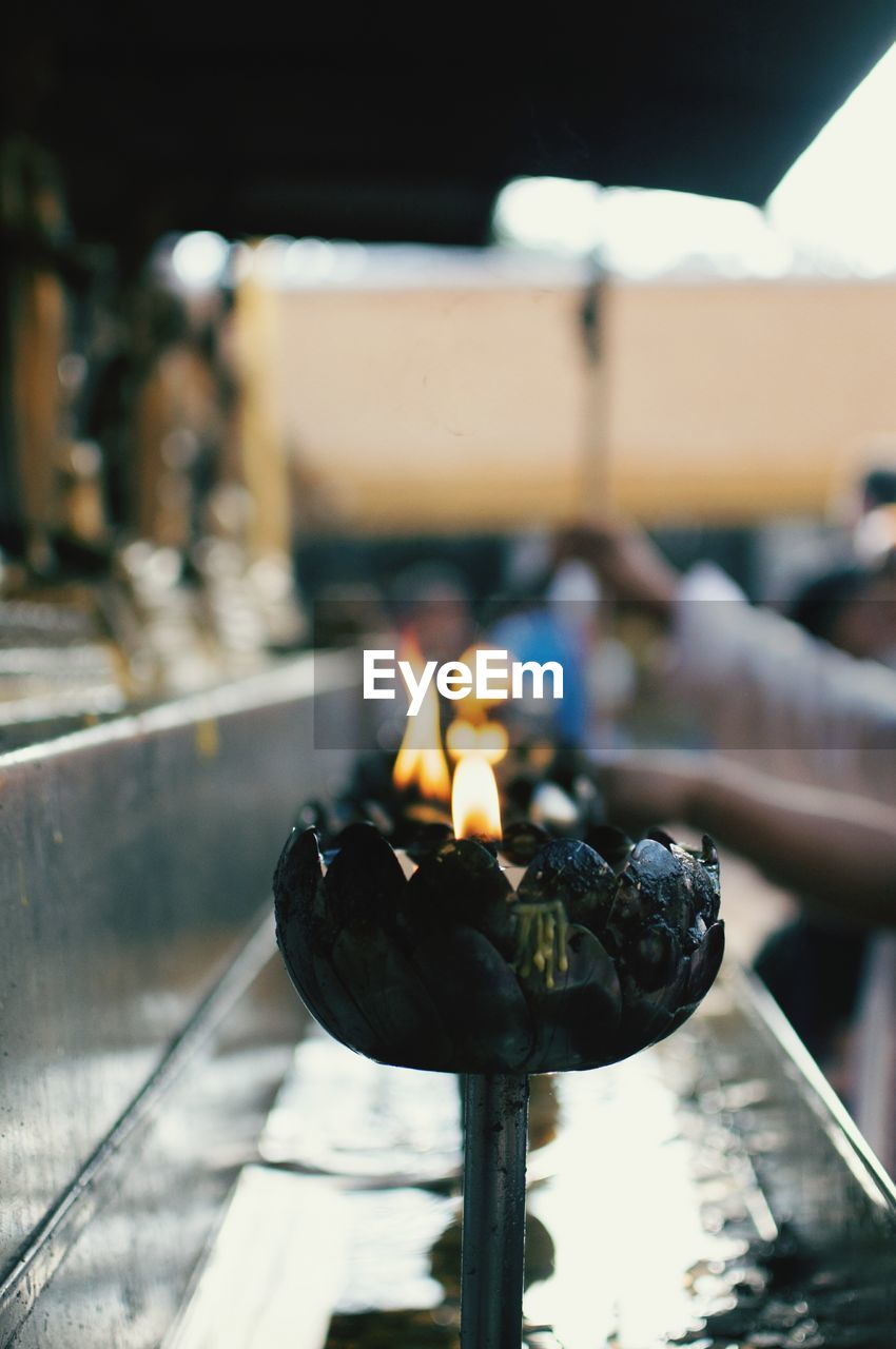 Close-up of diyas burning at temple