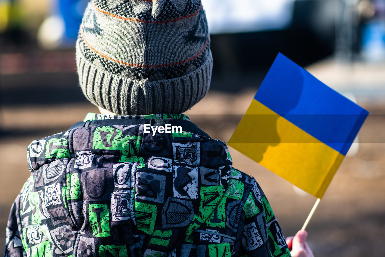 Child during a peaceful demonstration against war, putin and russia in support of ukraine, with flag