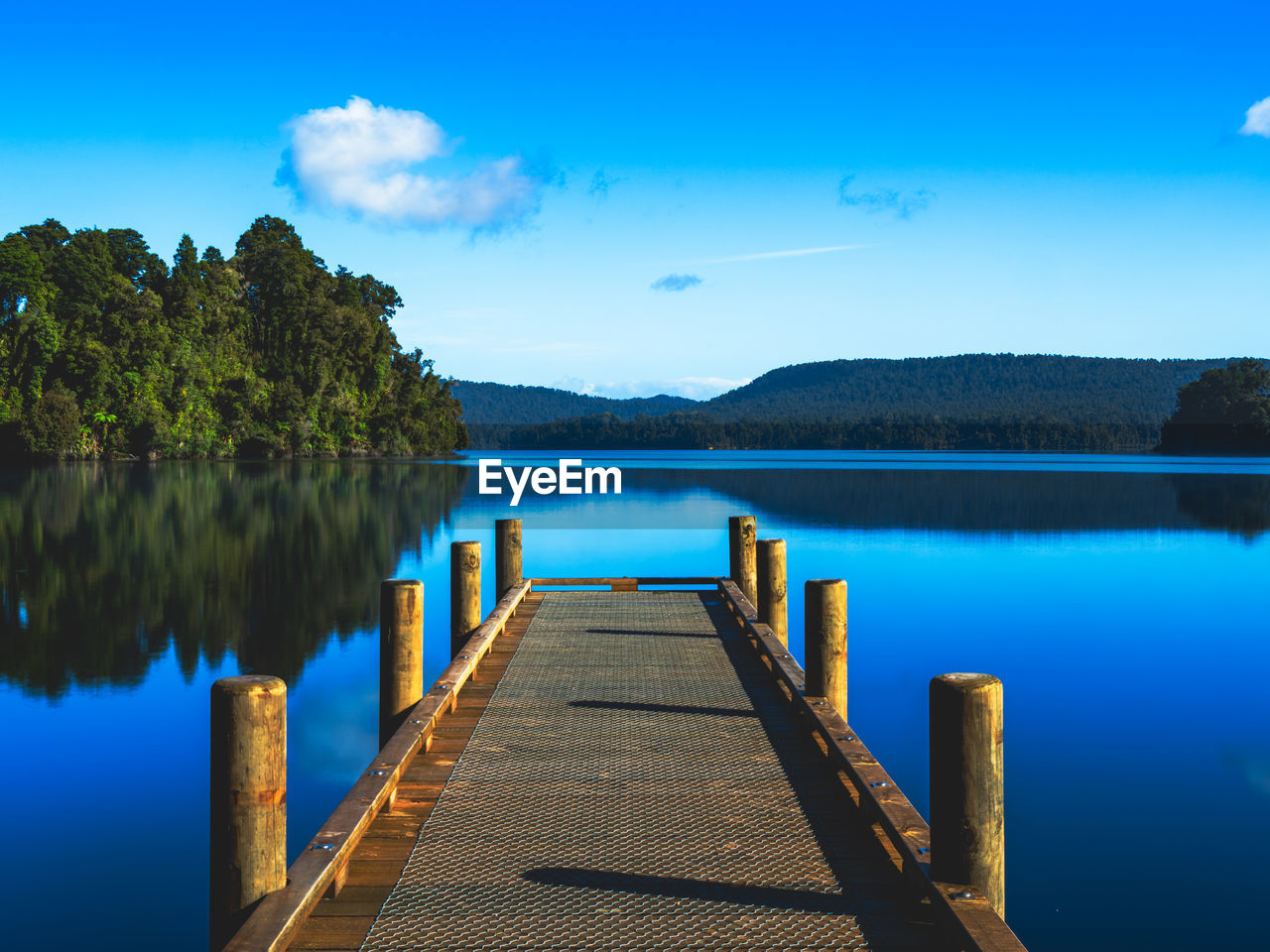 water, reflection, sky, scenics - nature, lake, tranquility, beauty in nature, nature, tranquil scene, blue, body of water, pier, jetty, tree, horizon, wood, reservoir, shore, no people, land, dusk, landscape, plant, mountain, cloud, environment, idyllic, bay, travel destinations, morning, beach, non-urban scene, outdoors, travel, summer, the way forward, architecture, day, footpath, forest, clear sky, sunlight, trip, diminishing perspective, vacation, relaxation, holiday, tourism, boardwalk