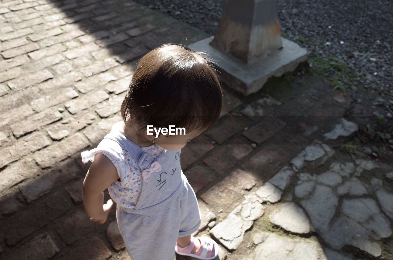 HIGH ANGLE VIEW OF WOMAN LOOKING AT FOOTPATH