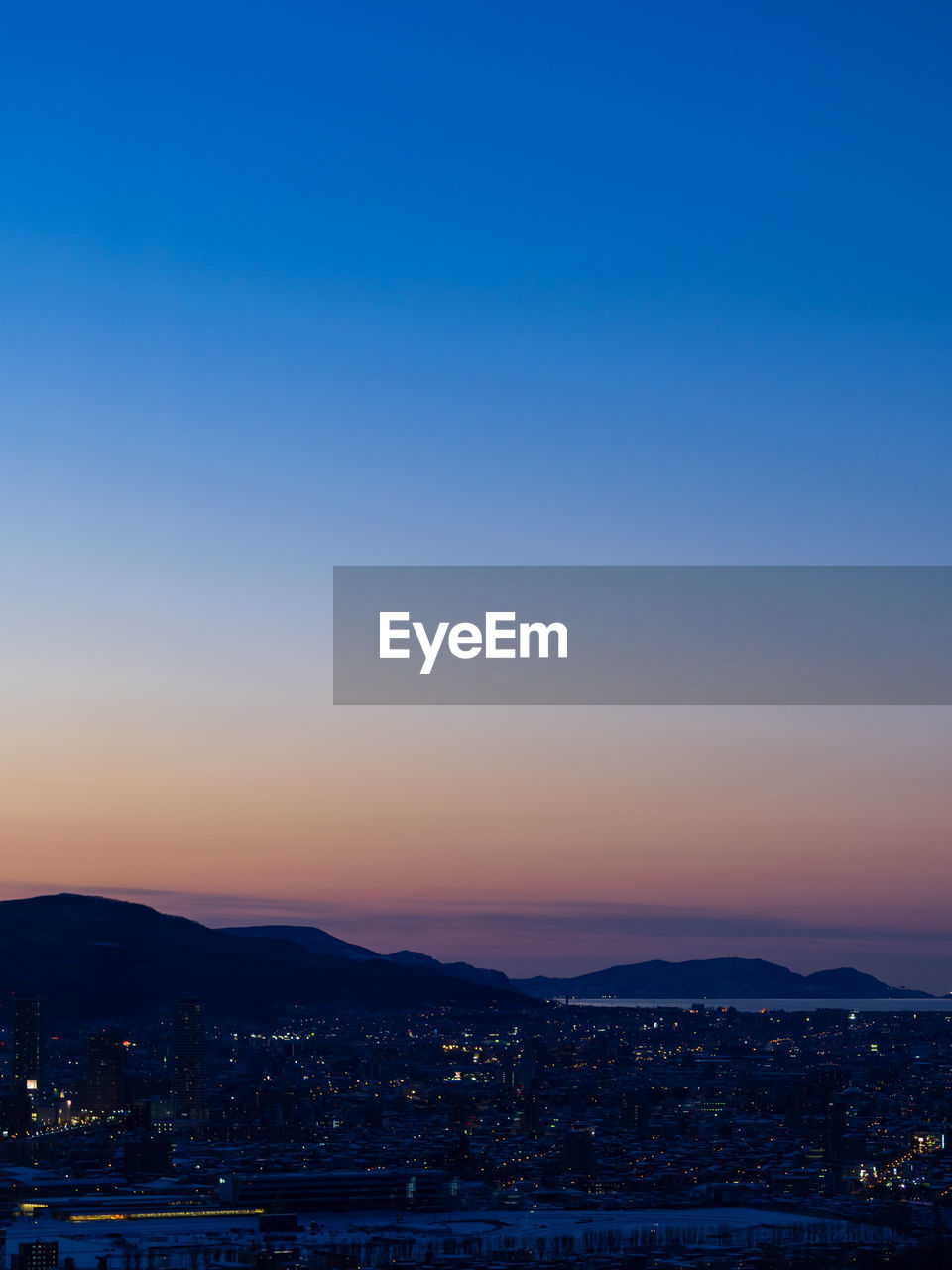 Cityscape against blue sky during sunset