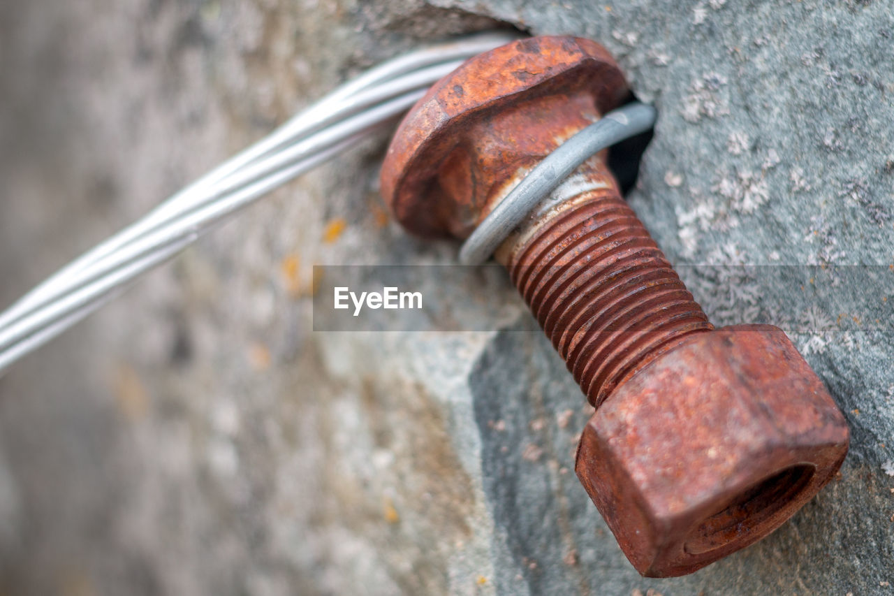 Close-up of rusty nut on wall