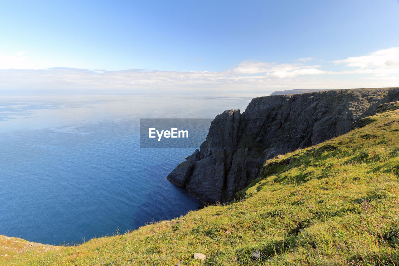 Scenic view of sea and mountains against sky