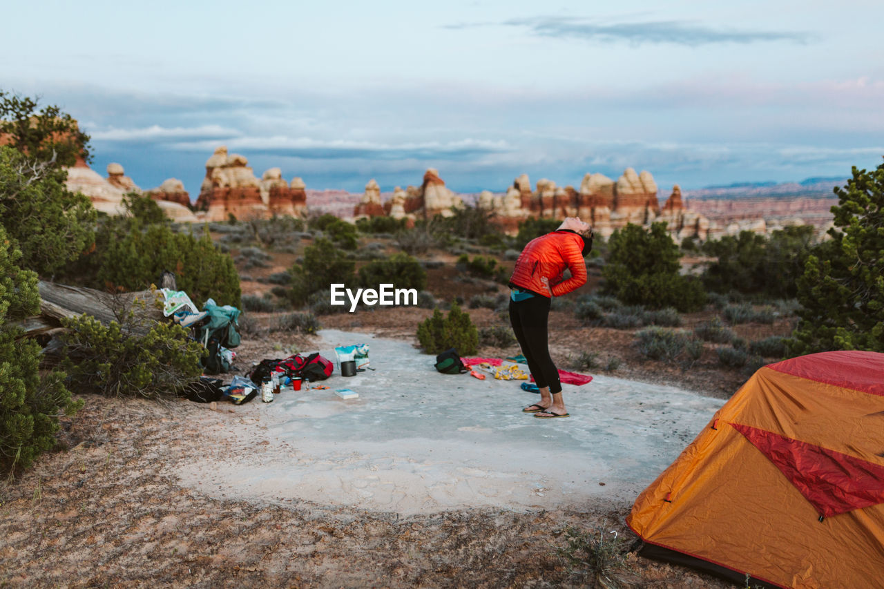 Female camper does backbend stretches at dusk in the desert