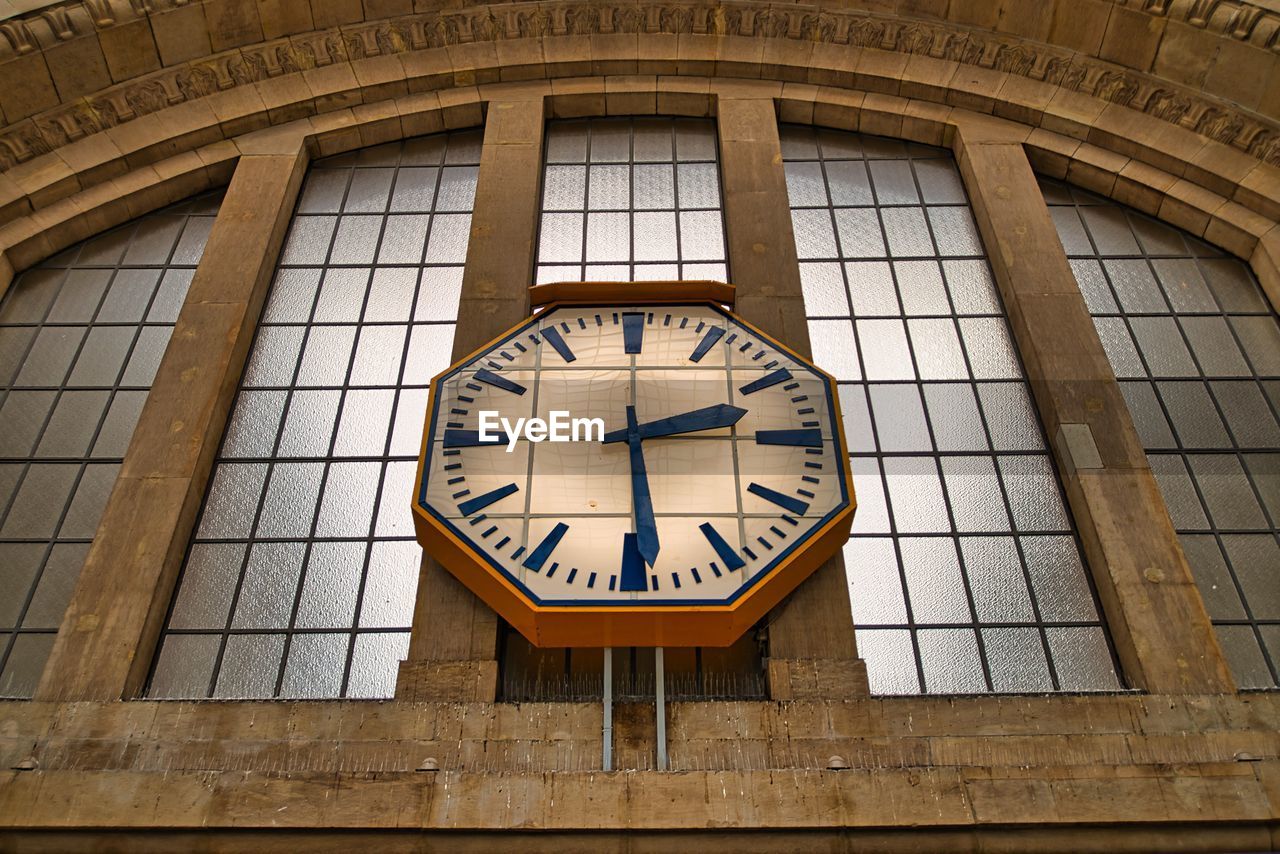 Low angle view of clock tower against wall