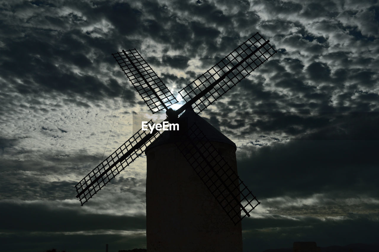 Traditional windmill against cloudy sky