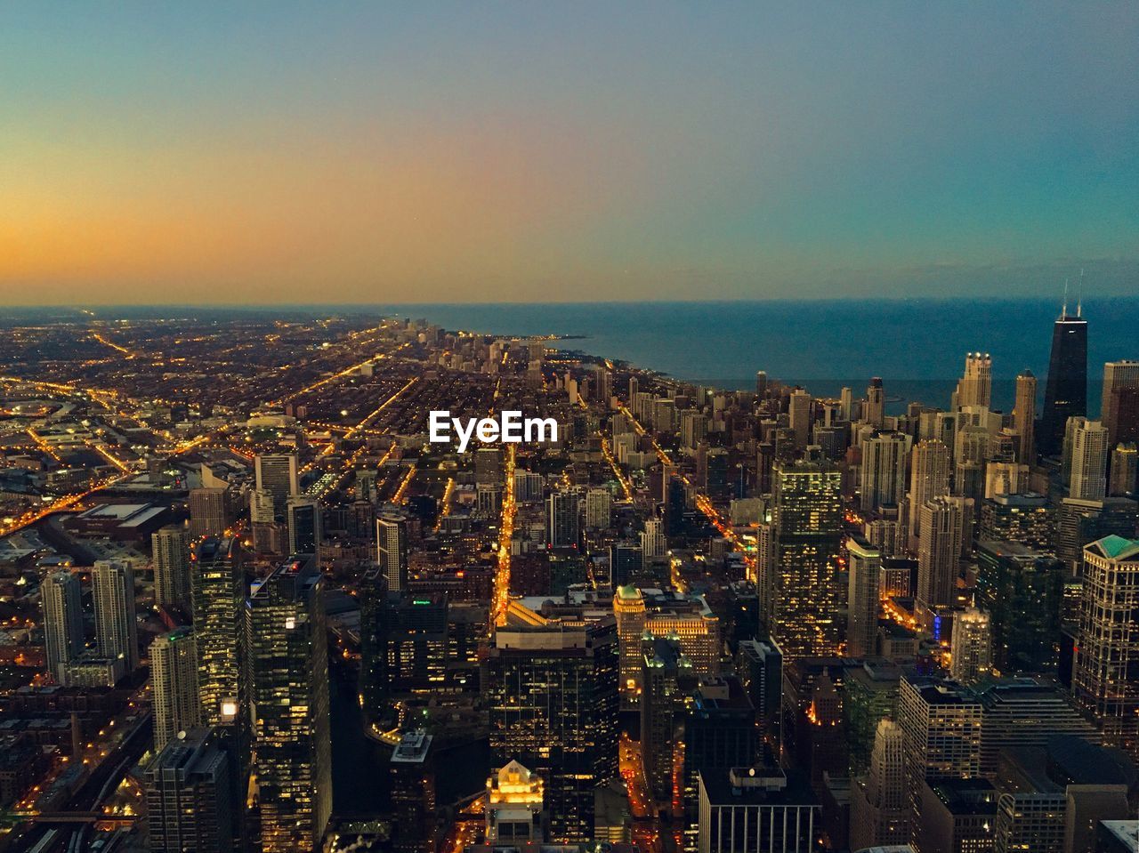 High angle view of illuminated city buildings against sky