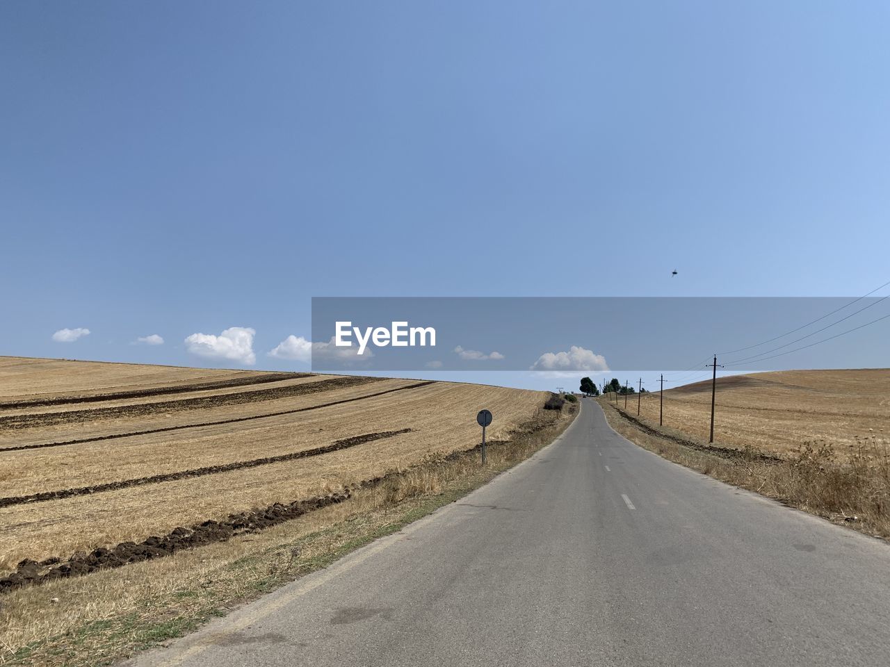 Road amidst field against sky