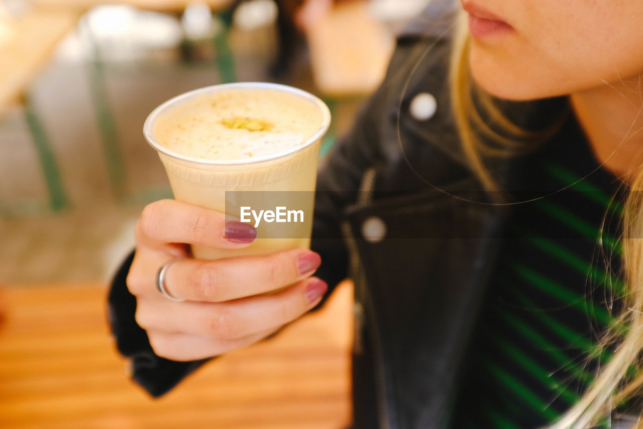 MIDSECTION OF WOMAN HOLDING COFFEE