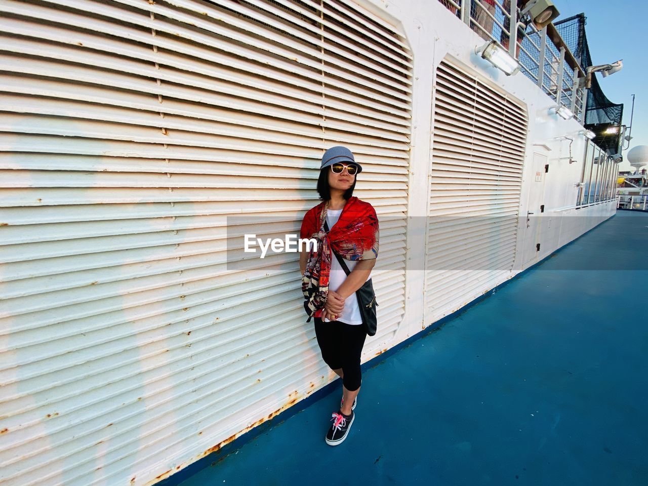 Woman wearing sunglasses standing in ship
