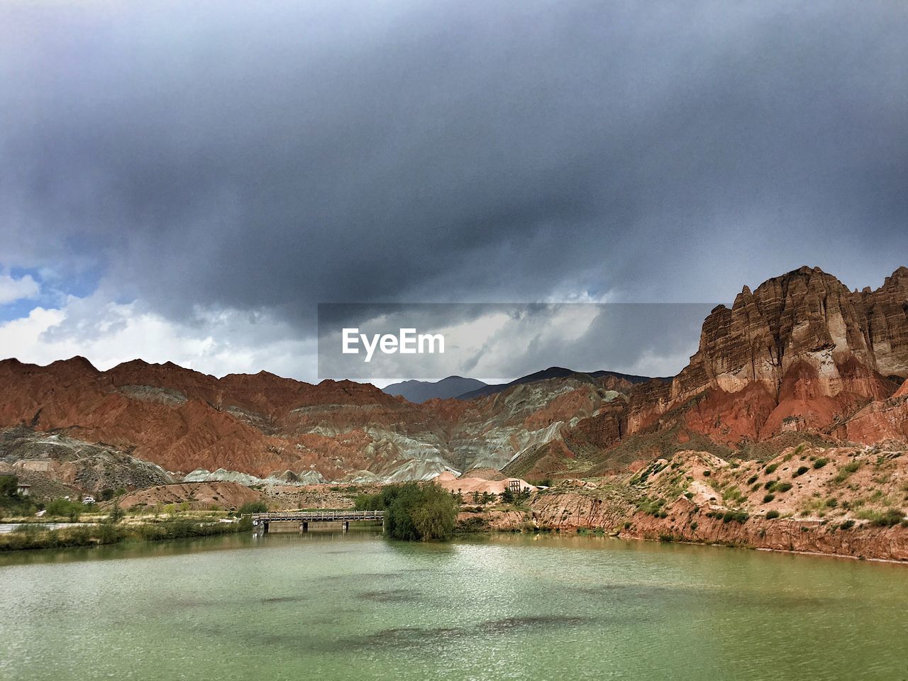 Scenic view of river against cloudy sky