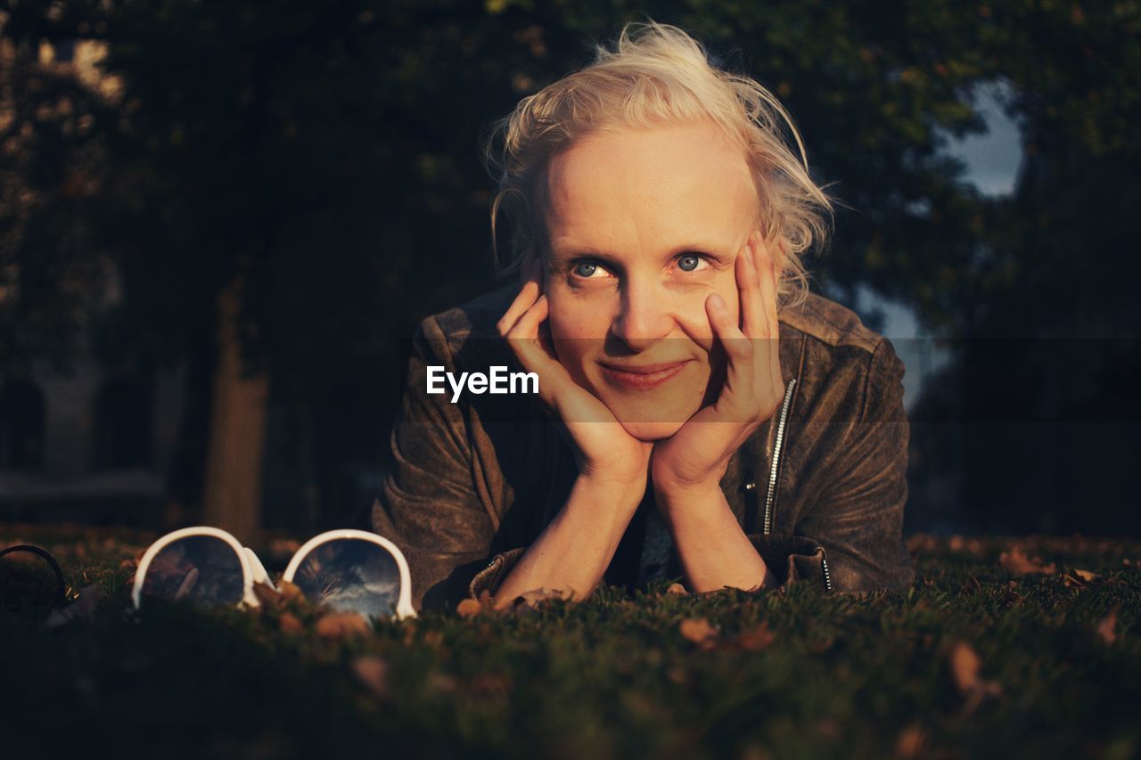 Woman looking away while lying on field