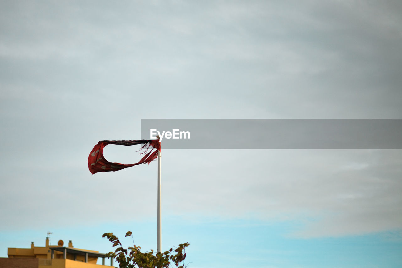 Low angle view of flags hanging against sky