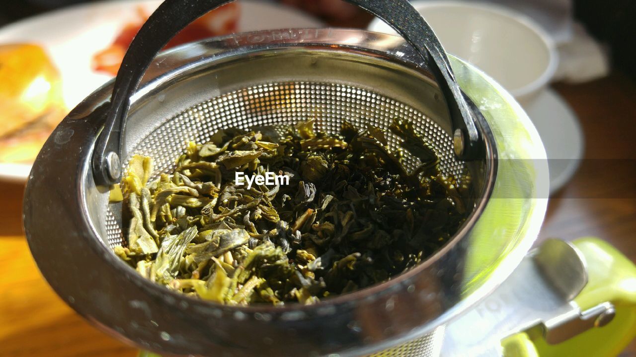 High angle view of green tea in strainer