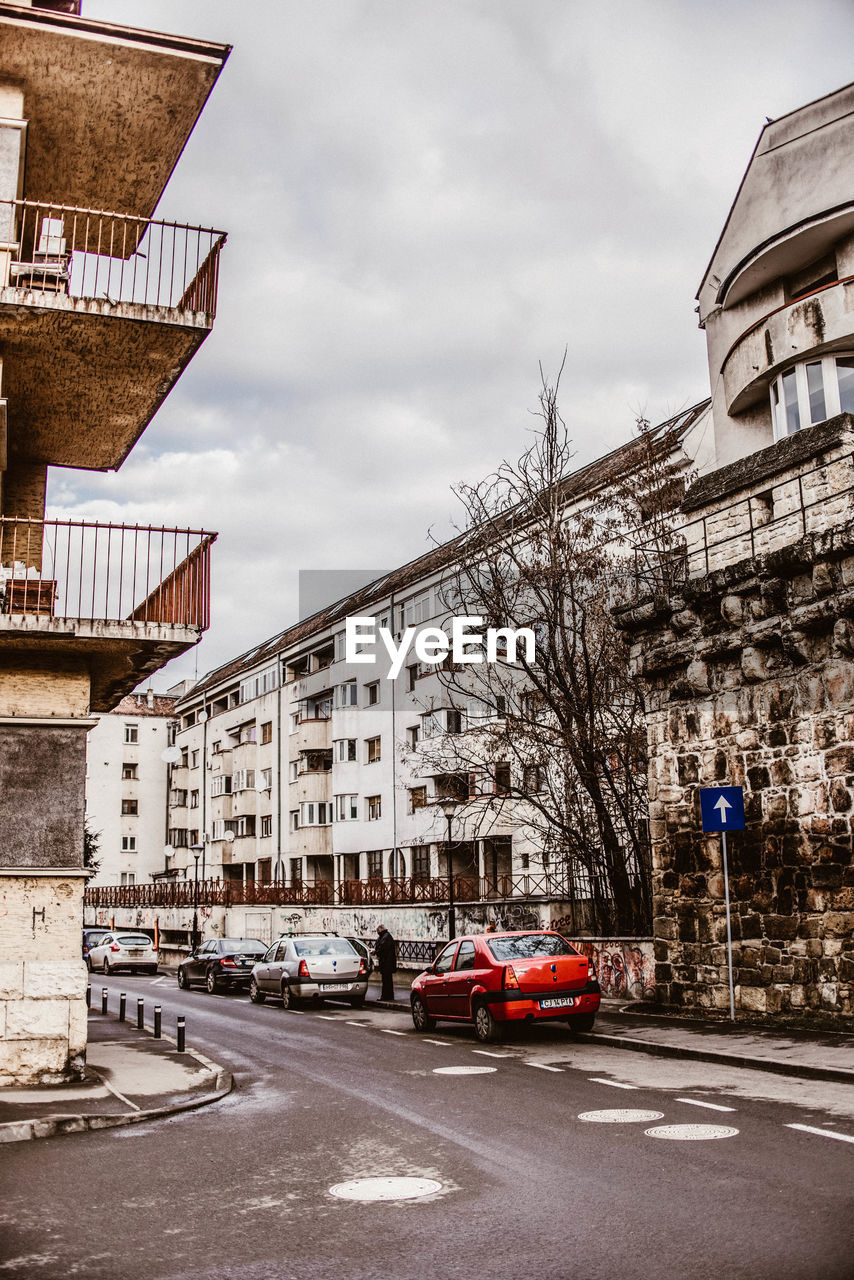 CARS ON STREET BY BUILDINGS AGAINST SKY