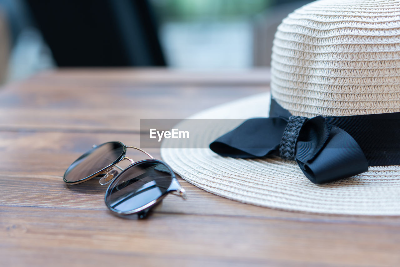 CLOSE-UP OF SUNGLASSES ON TABLE AT CAFE