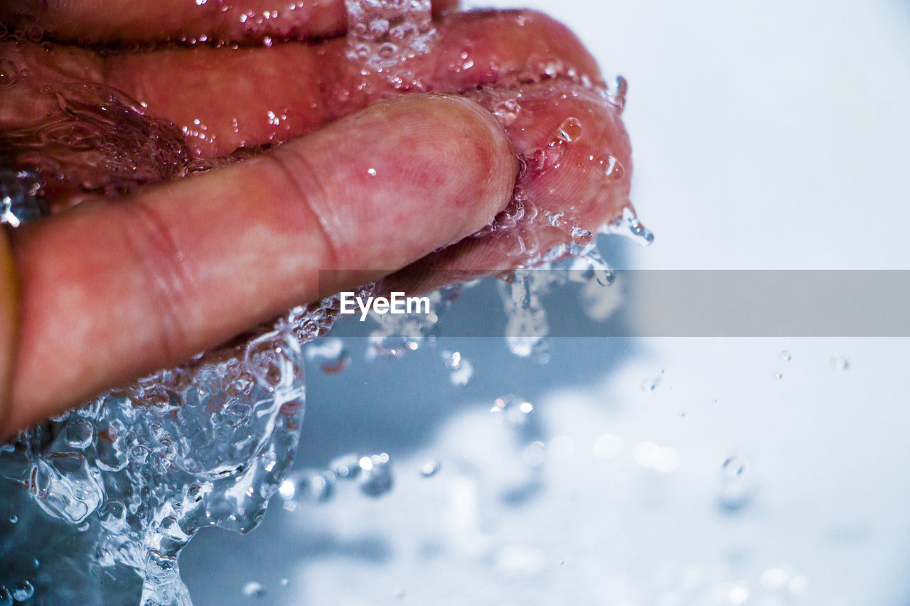 Close-up of water splashing on hand