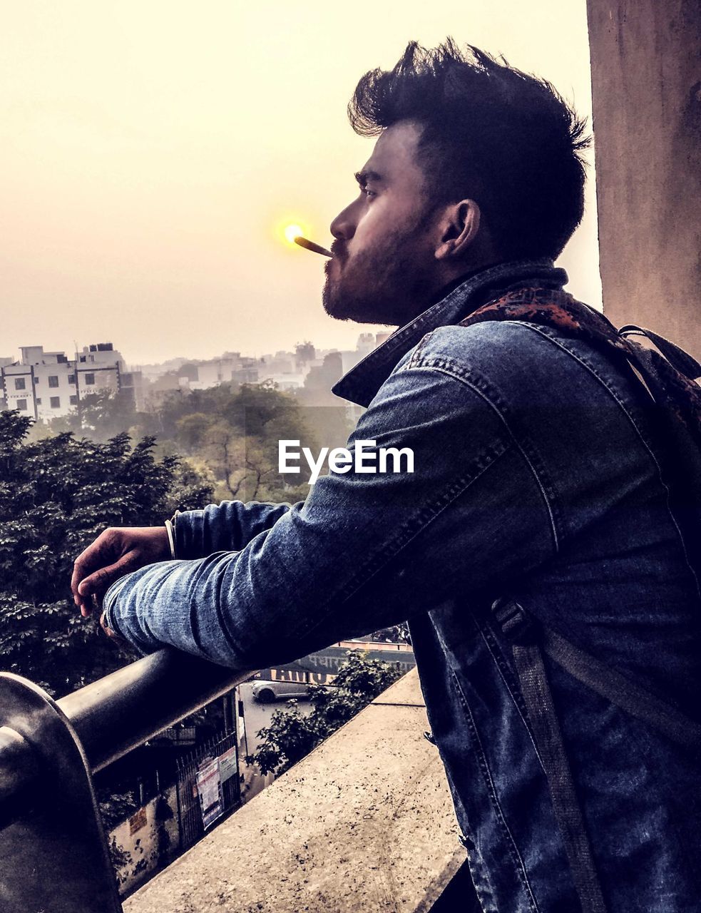 one person, adult, men, sky, architecture, casual clothing, young adult, lifestyles, side view, leisure activity, city, nature, black, person, beard, looking, jeans, portrait, facial hair, relaxation, outdoors, standing, looking away, photo shoot, contemplation, building exterior, profile view, sunlight, built structure, waist up, blue, clothing, city life, day, sunset