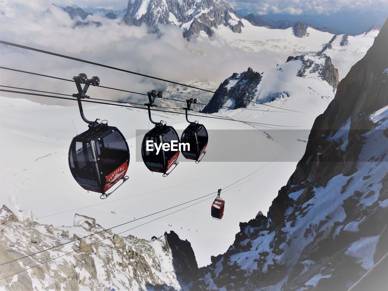 LOW ANGLE VIEW OF SKI LIFT AGAINST MOUNTAINS