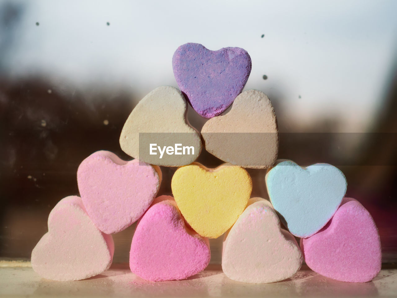 Close-up of heart shape decoration on table against glass window