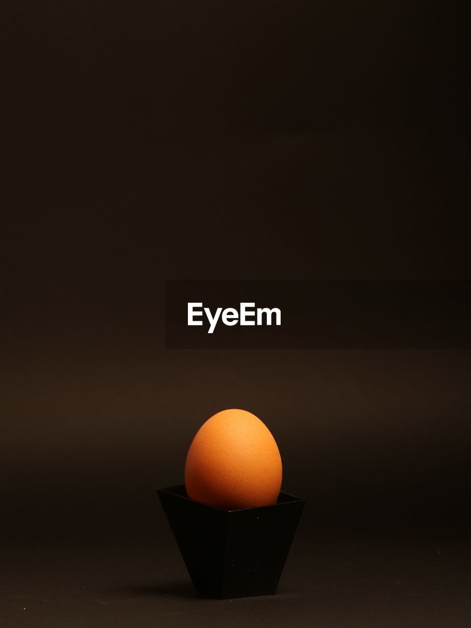 Close-up of egg on table against black background