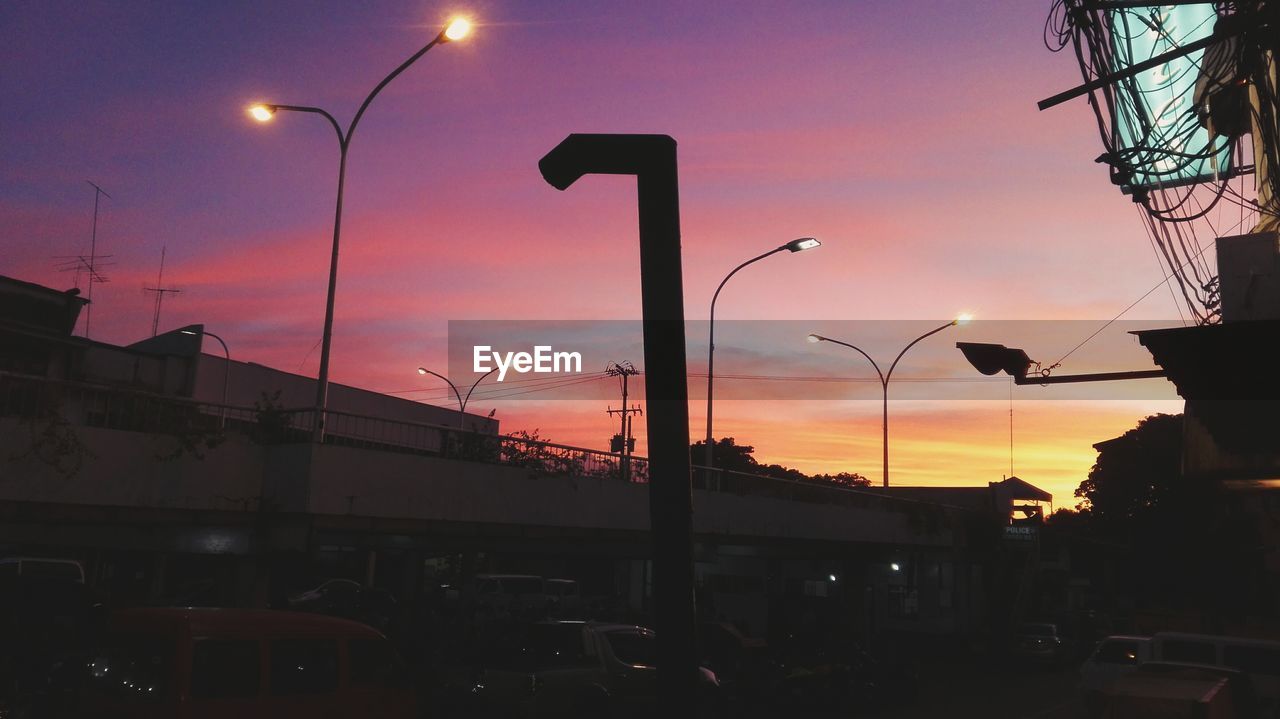 SILHOUETTE OF STREET LIGHTS AGAINST DRAMATIC SKY