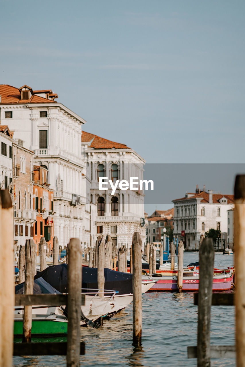 Wooden posts and boats on grand canal in city