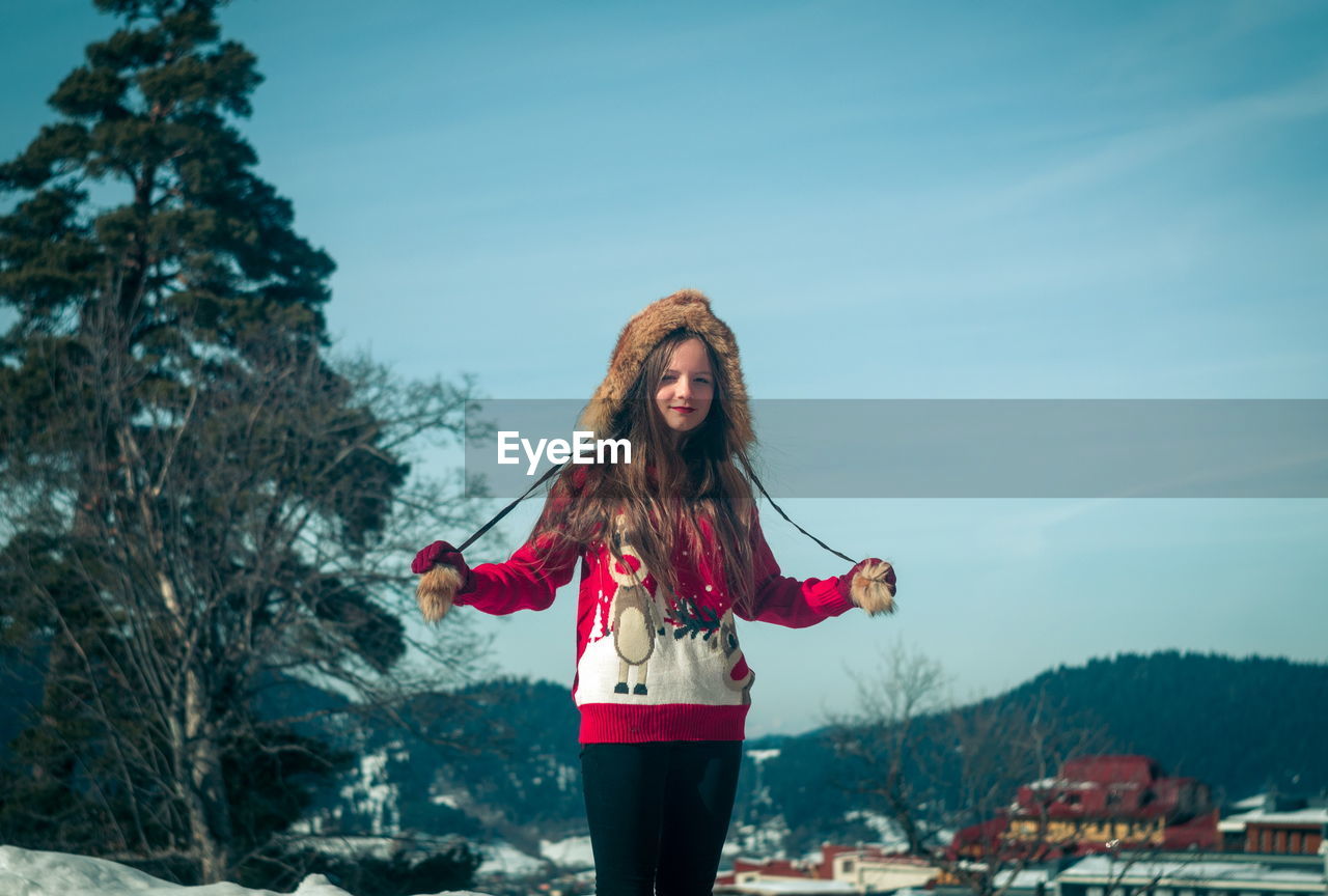 Portrait of smiling girl wearing fur hat while standing outdoors