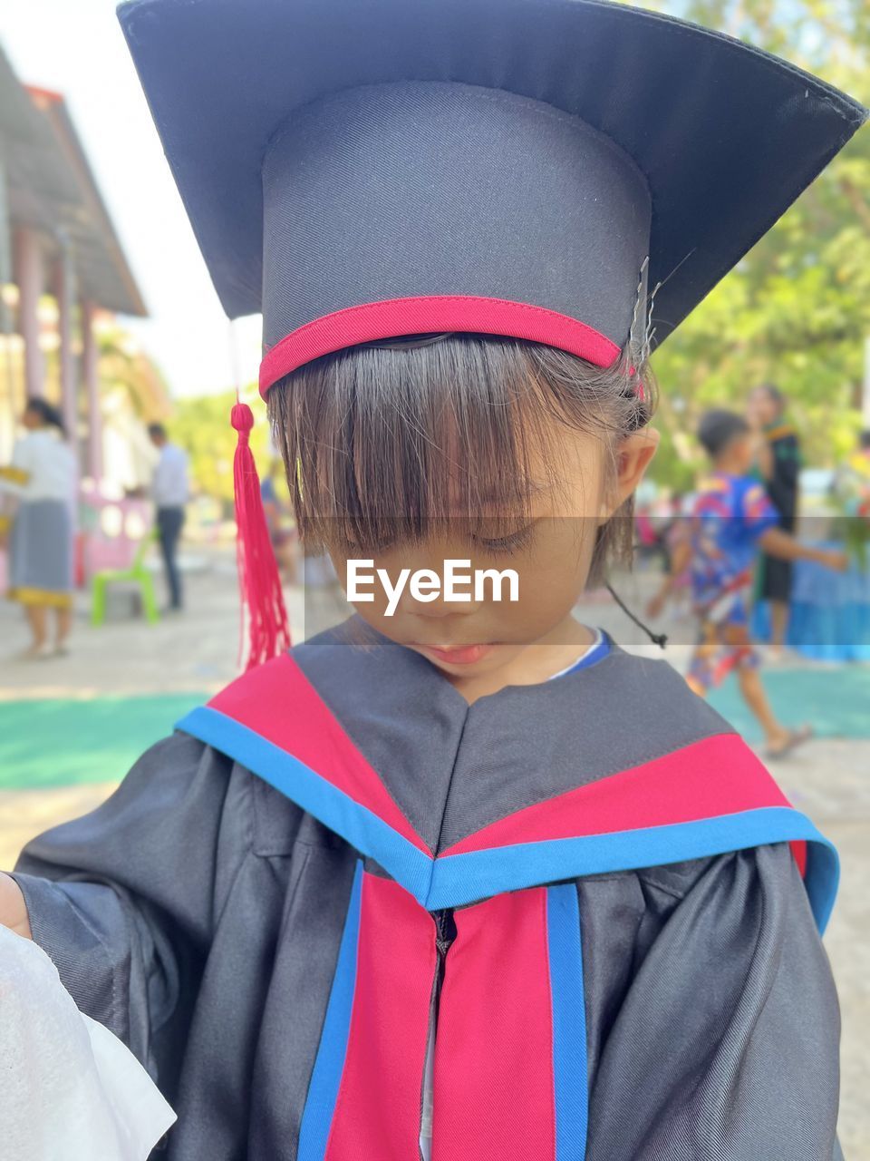 graduation, child, childhood, academic dress, one person, mortarboard, education, portrait, men, student, clothing, focus on foreground, school, graduation gown, day, learning, happiness, achievement, smiling, standing, emotion, front view, university student, celebration, outdoors, event, headshot, costume, female, innocence, looking at camera, waist up, holding, hat, cute, human face, success