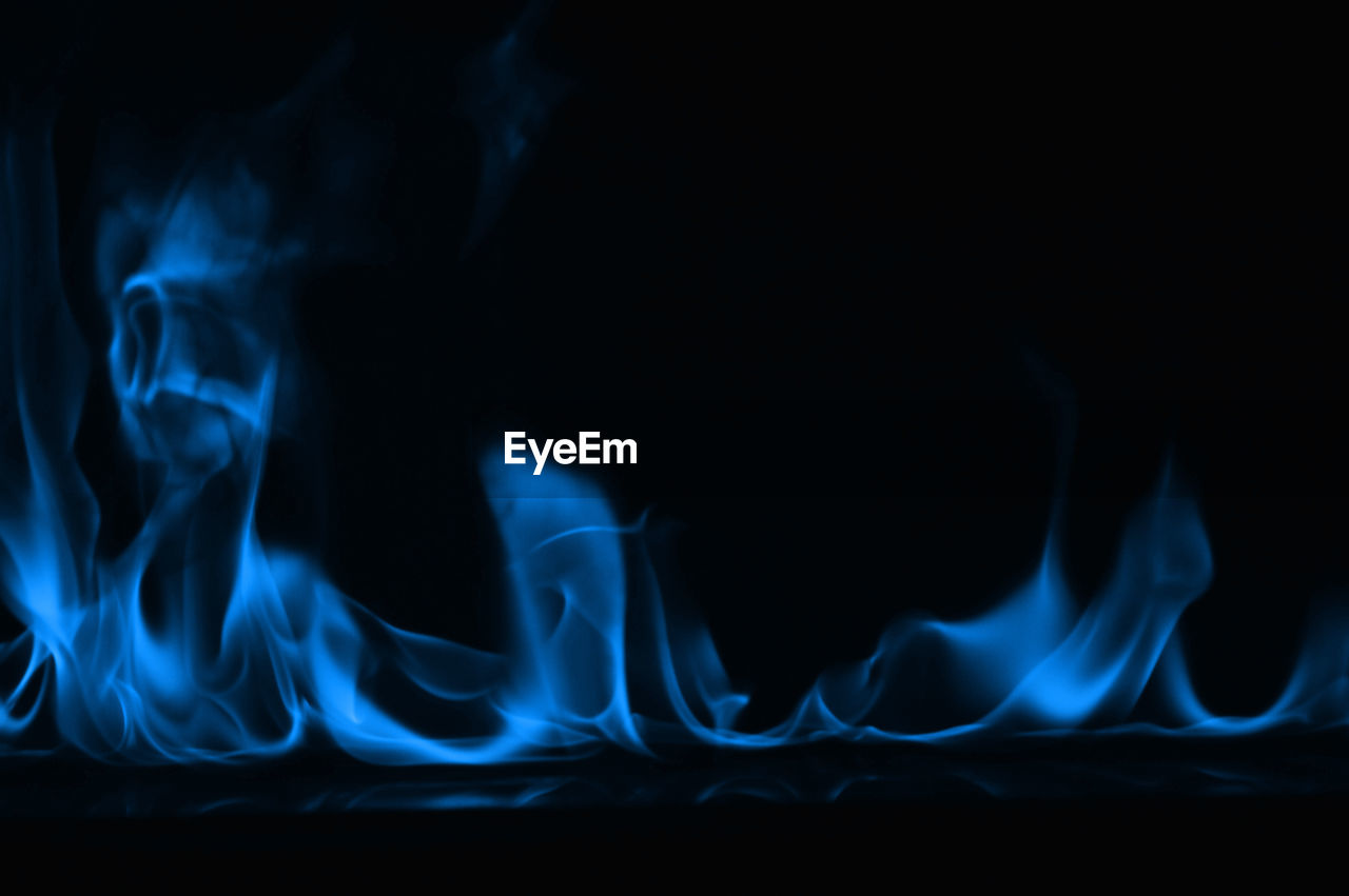 Close-up of blue smoke against black background