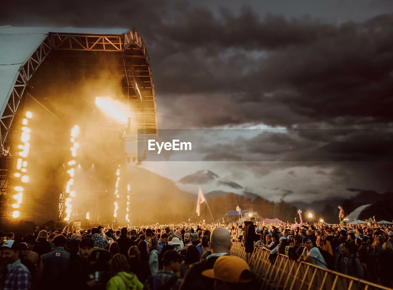 PEOPLE AT MUSIC CONCERT AGAINST SKY AT NIGHT