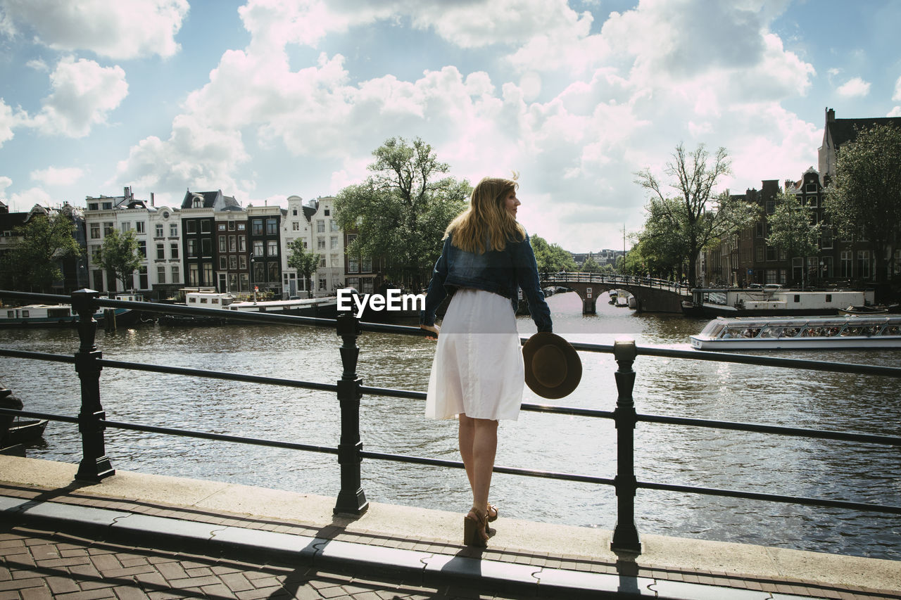 Woman in white dress overlooking city and canal