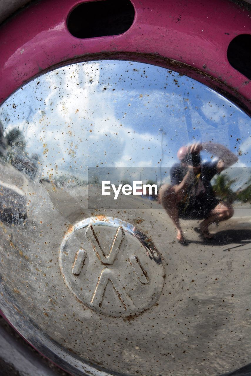 CLOSE-UP OF REFLECTION OF WOMAN IN CAR