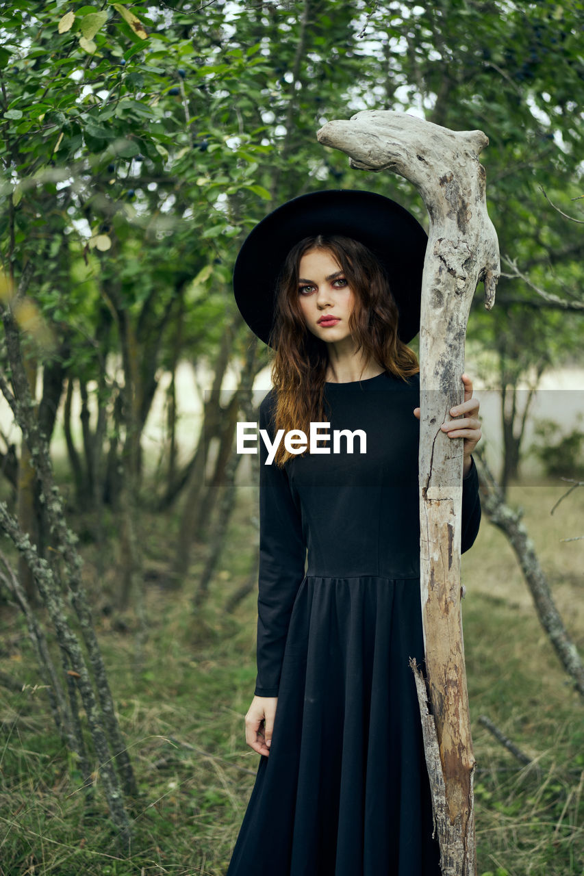 portrait of young woman standing in forest