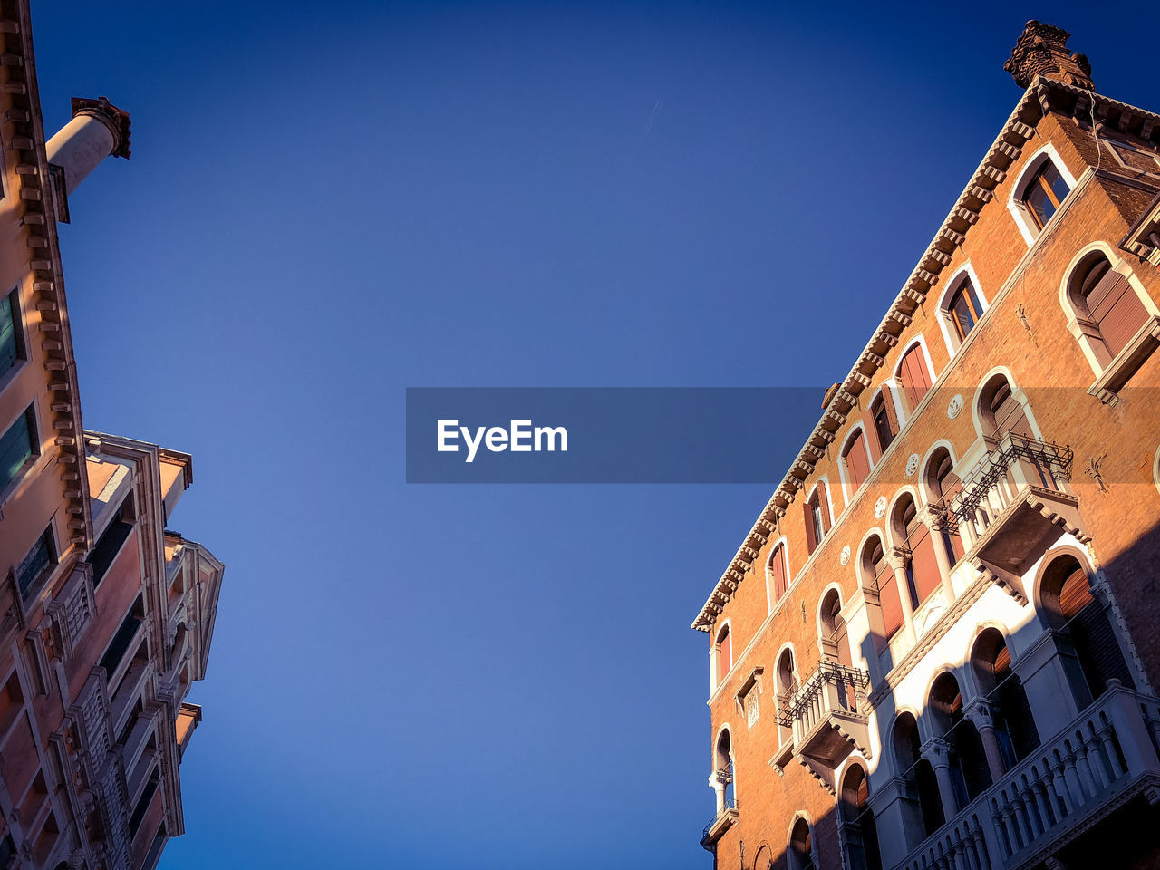 Low angle view of venetian building against blue sky